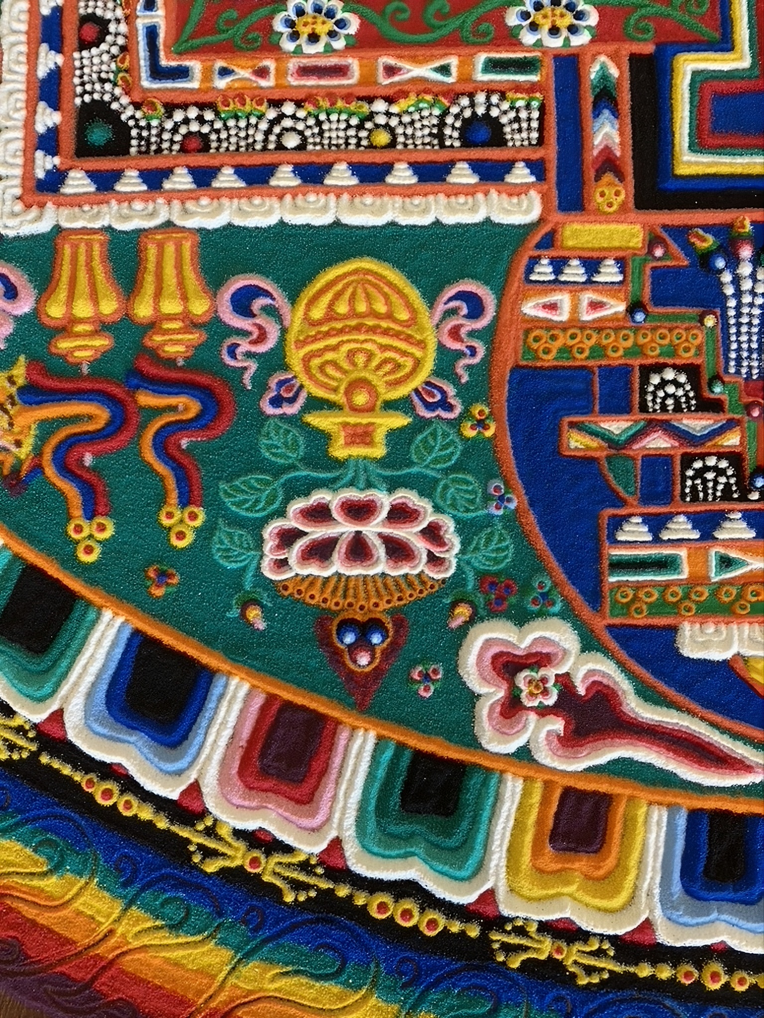 A close-up of a colorful, geometric pattern from a mandala.