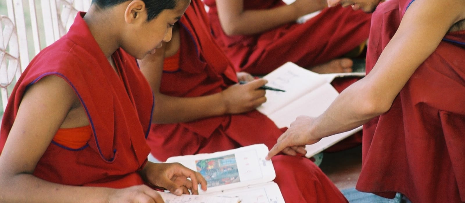 Artistic image of monks writing in notebooks.