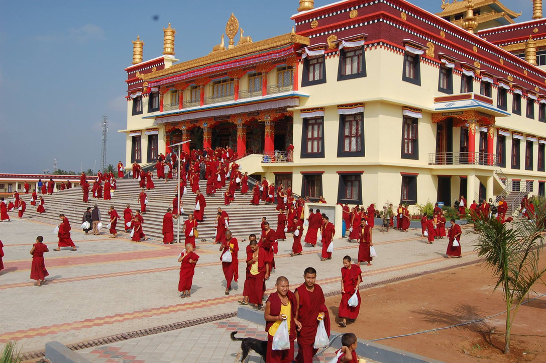 A view of the main temple with golden roofs and people in the courtyard.