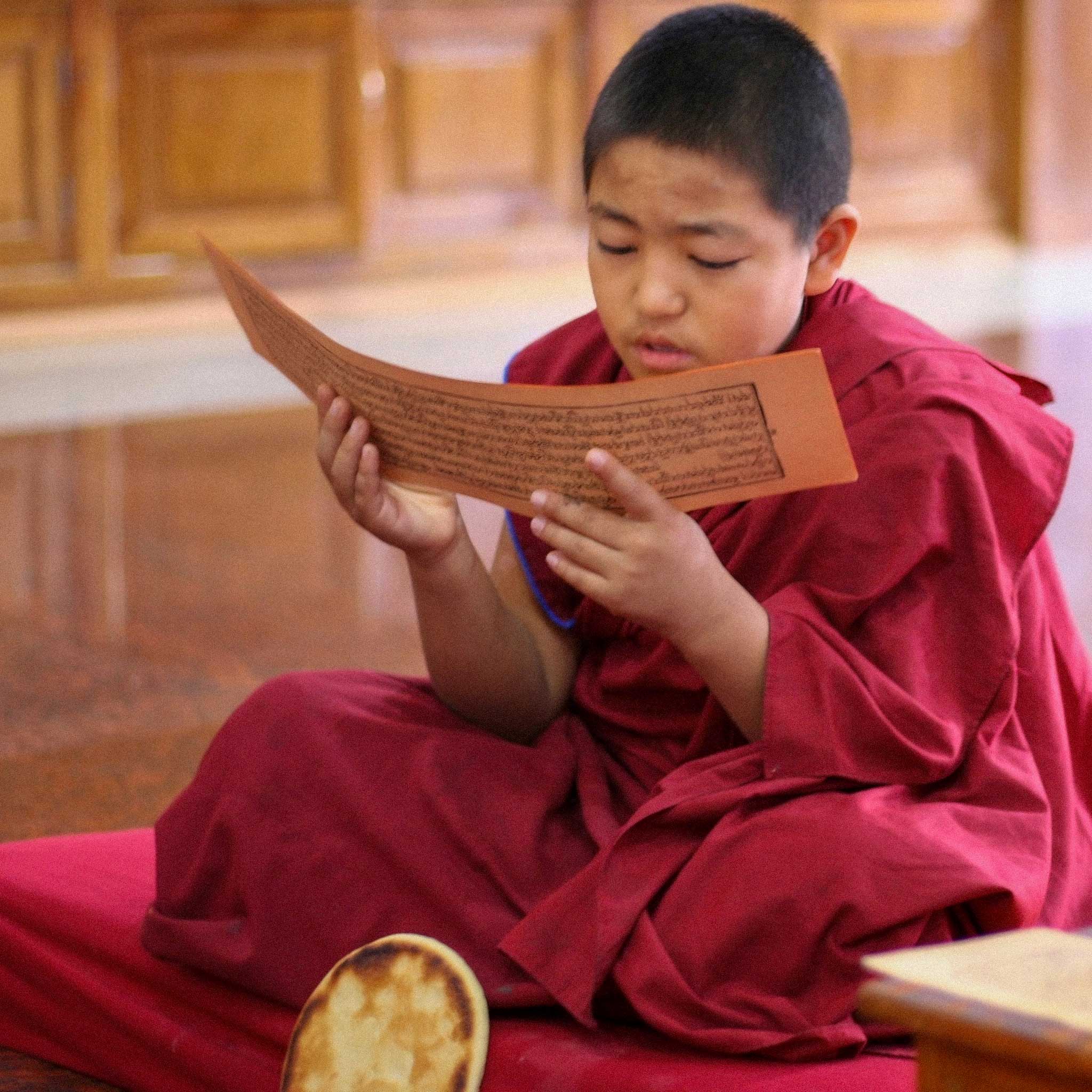 A monk reading a traditional long form scripture.