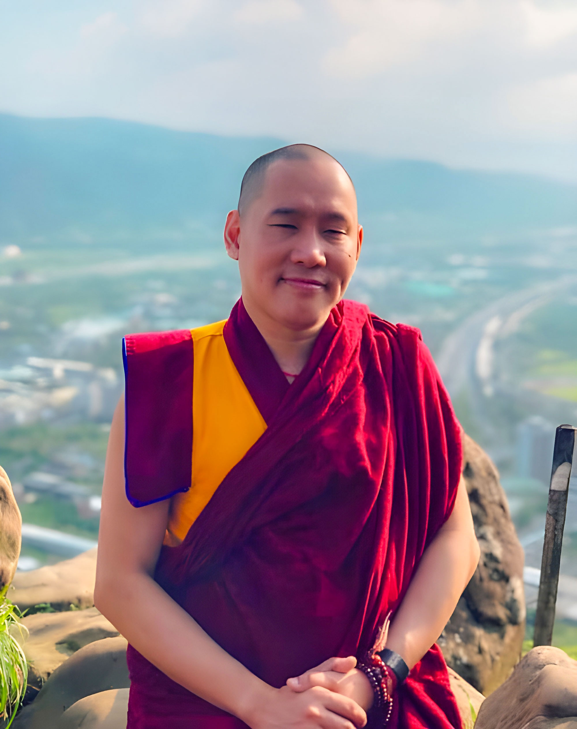 Portrait of Khen Rinpoche Zeekgyab Tulku The Present Abbot up high with a mountainous background.