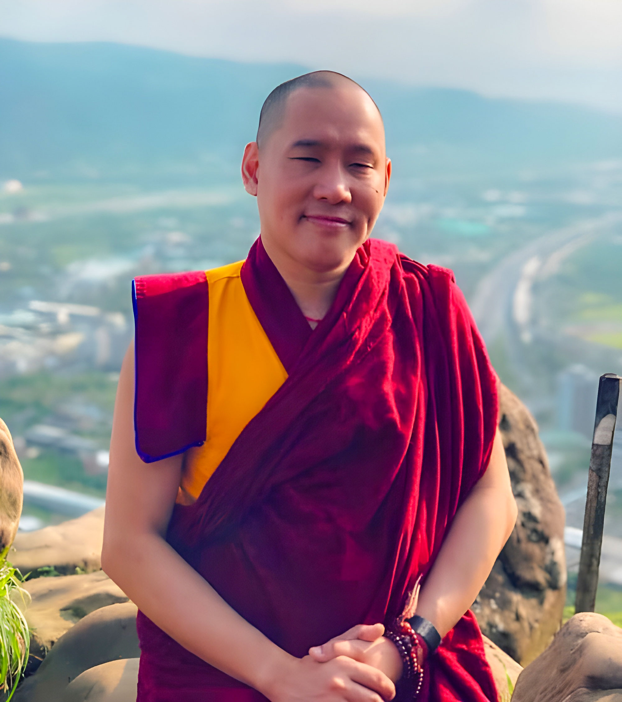 Portrait of Khen Rinpoche Zeekgyab Tulku The Present Abbot up high with a mountainous background.