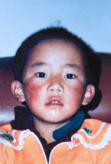 A close-up of a young Gedhun Choekyi Nyima the 11th Panchen Lama looking directly at the camera.