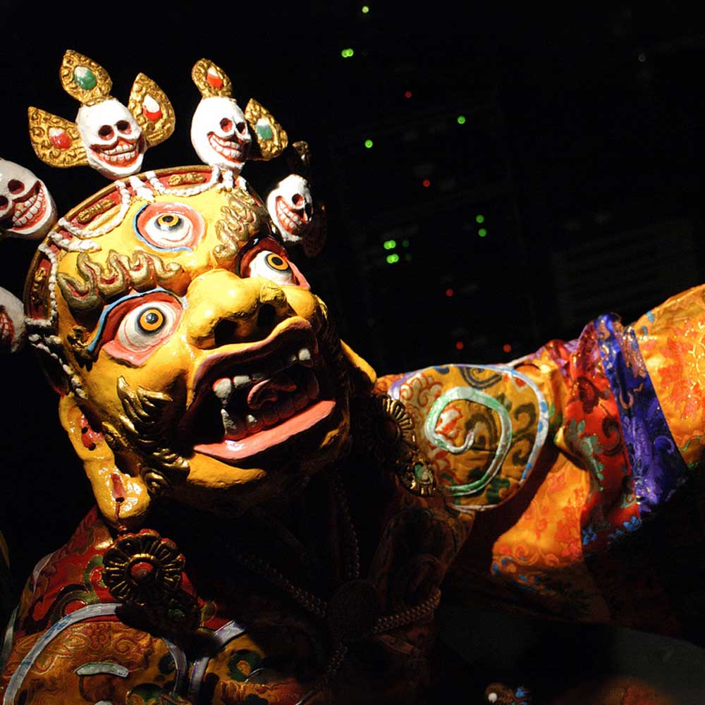 A close-up of a gold-faced ritual dance mask.
